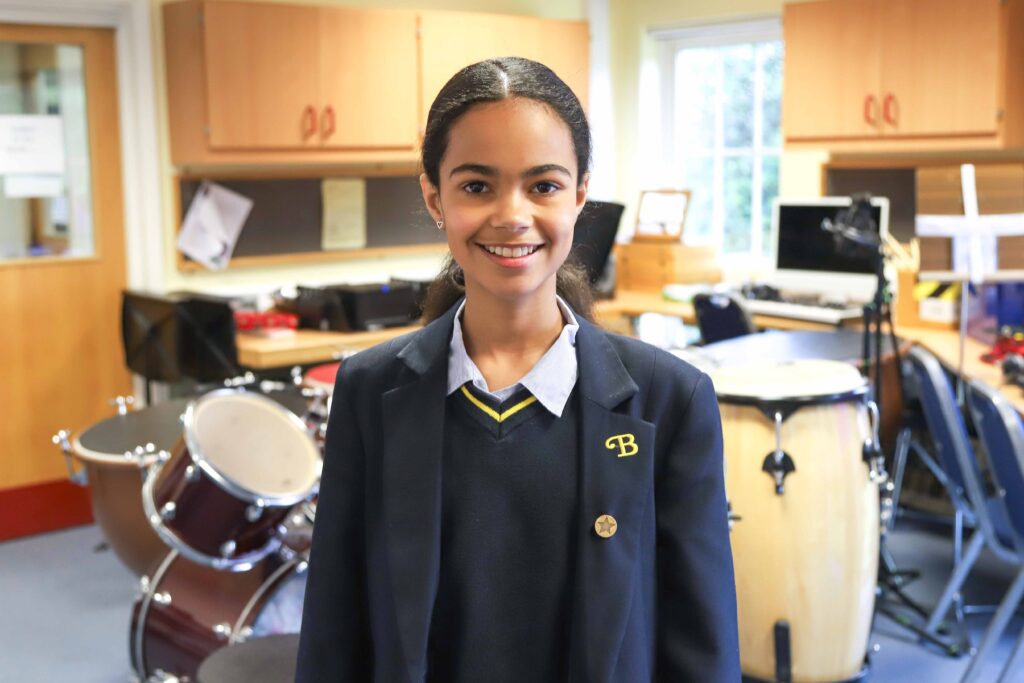 Hana-Ines standing in front of a drum kit
