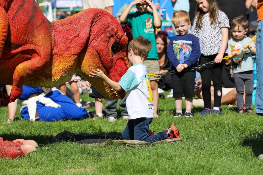 Children meeting the T-Rex at Haywards Heath Town Day 2026 in Victoria Park